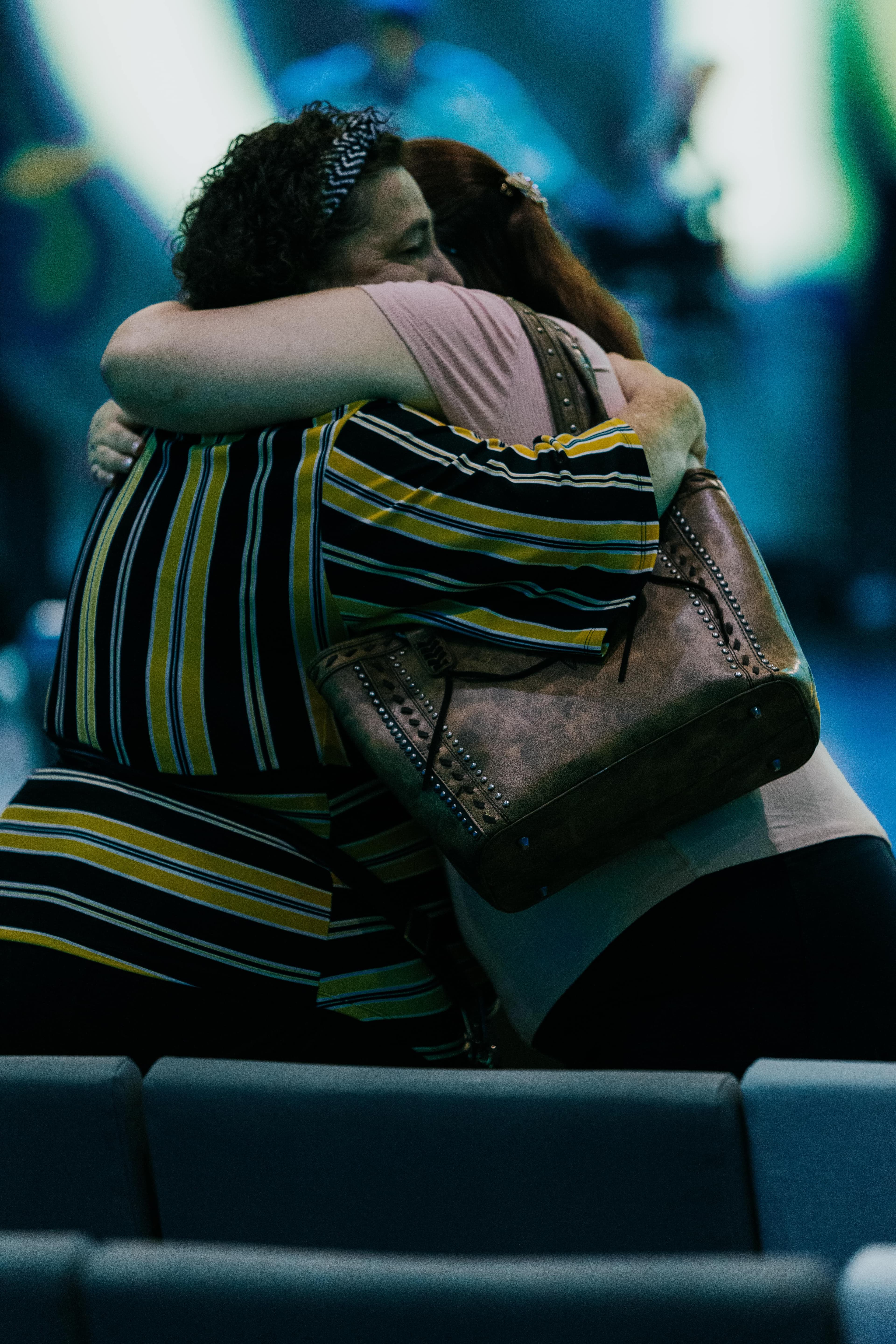 Two women hugging at church greeting eachother.
